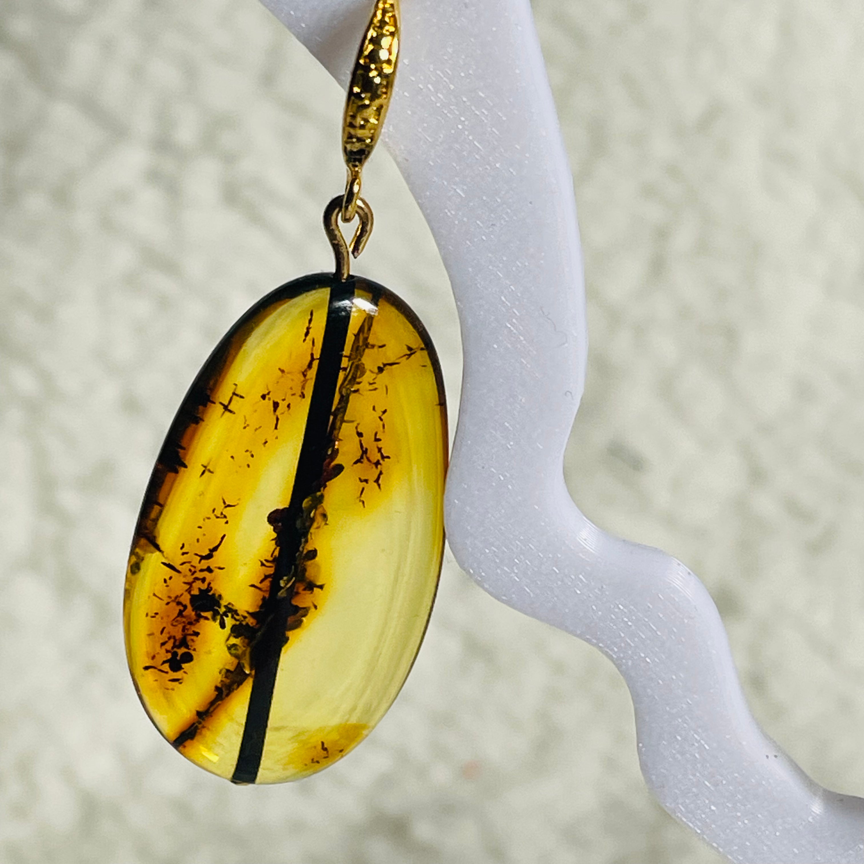 Natural green Baltic amber earrings on display