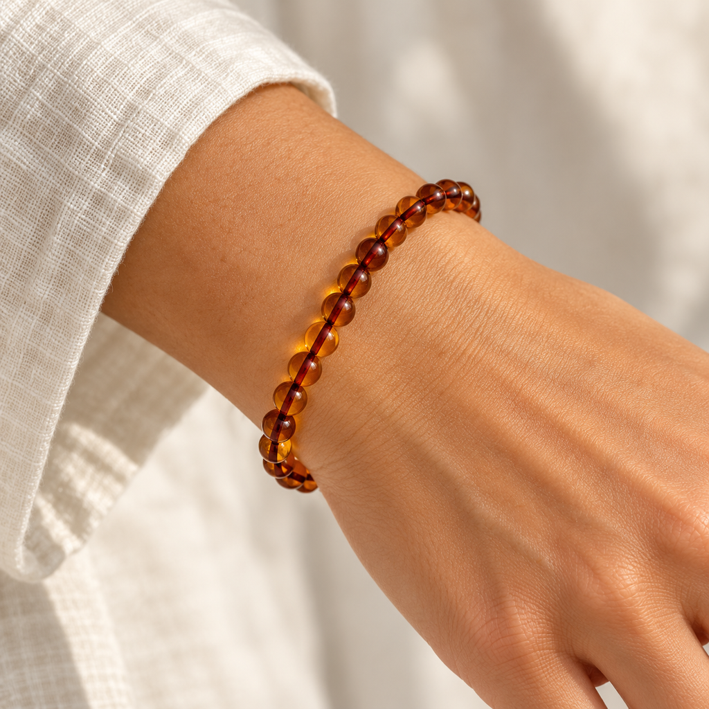 Honey-orange bracelet with translucent polished 5 mm round beads on brown cord, shown with a 21 cm circumference.